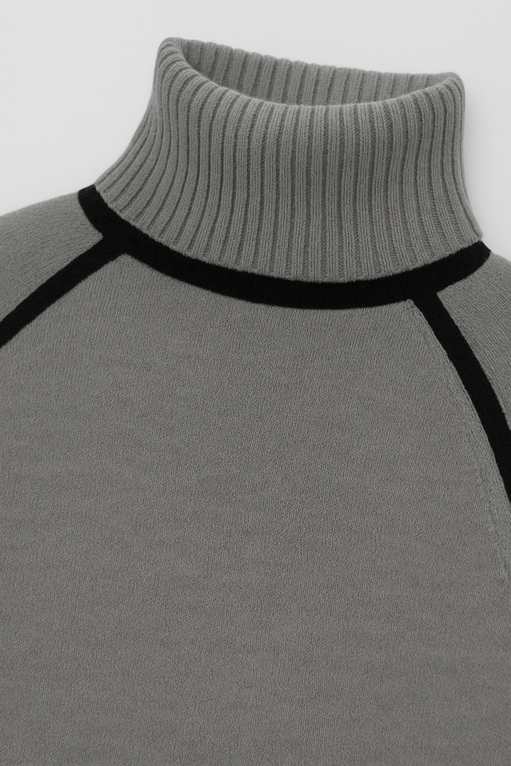 Gray turtleneck sweater with black accents on a light gray background