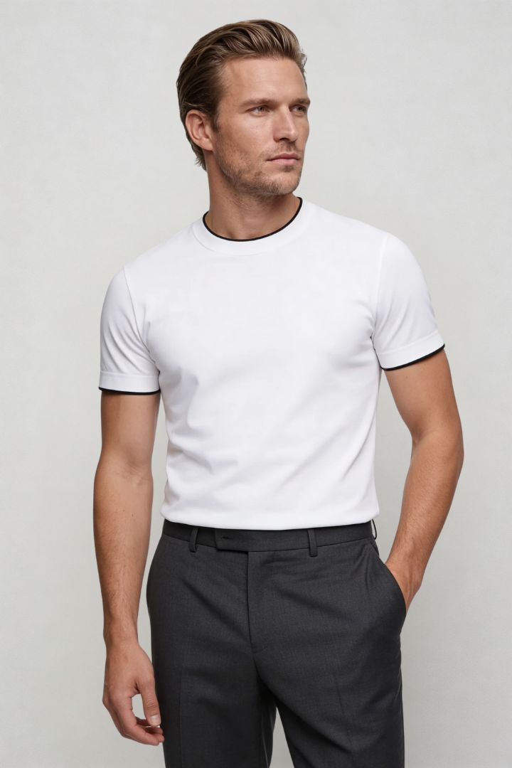 Man wearing the white Logan t-shirt and dark pants against a plain background side pose