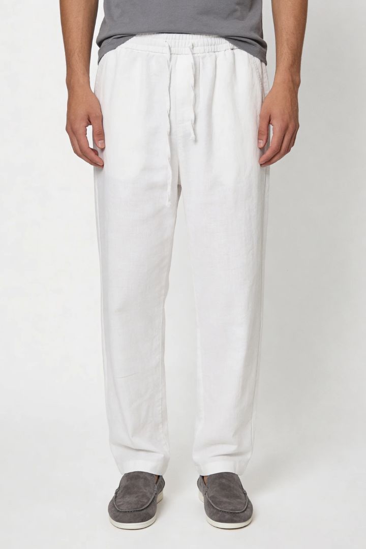 Man wearing white linen drawstring trousers relaxed straight fit lightweight summer linen pants