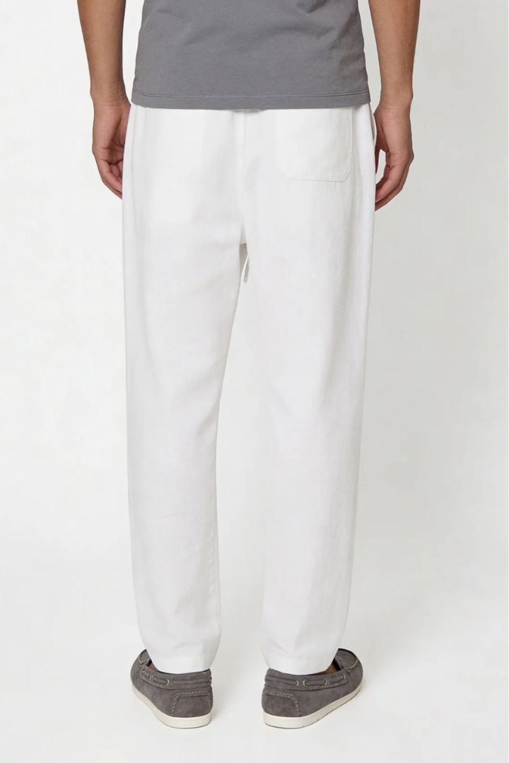 Man wearing white linen drawstring trousers relaxed straight fit lightweight summer linen pants back view