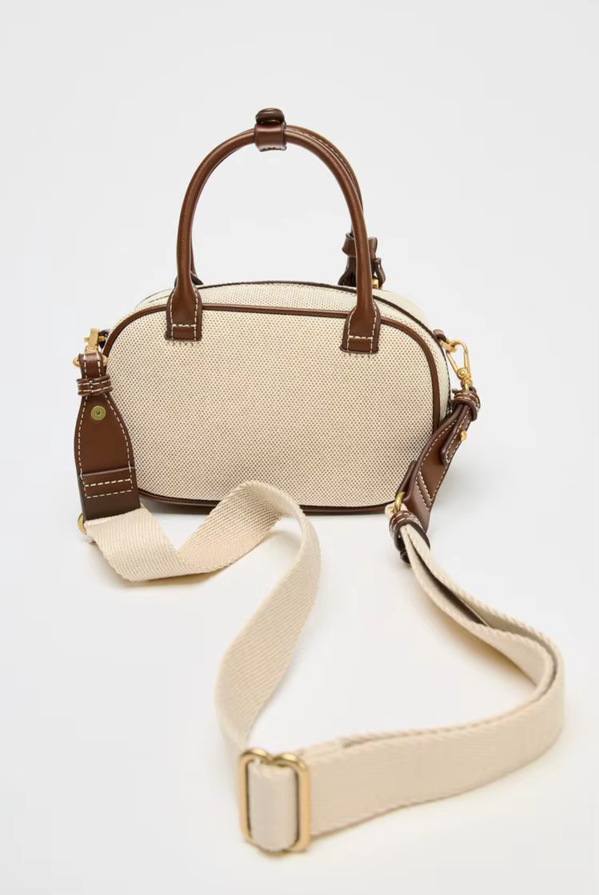 Beige handbag with brown accents on a white background