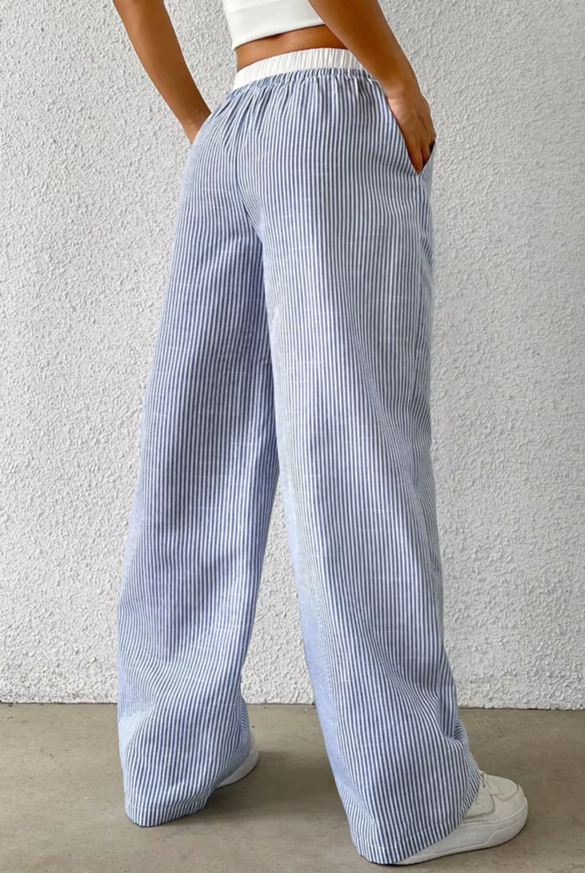 Person wearing blue and white striped pants against a plain background