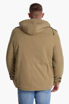 Person wearing a brown jacket with a hood on a white background