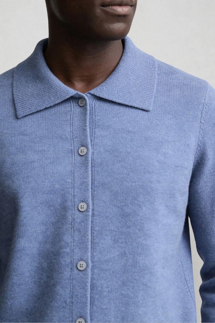 Men’s 100% wool knit cardigan sweater in blue with button front and classic collar design close-up