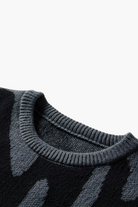 Close-up of a black sweater with a pattern on a white background