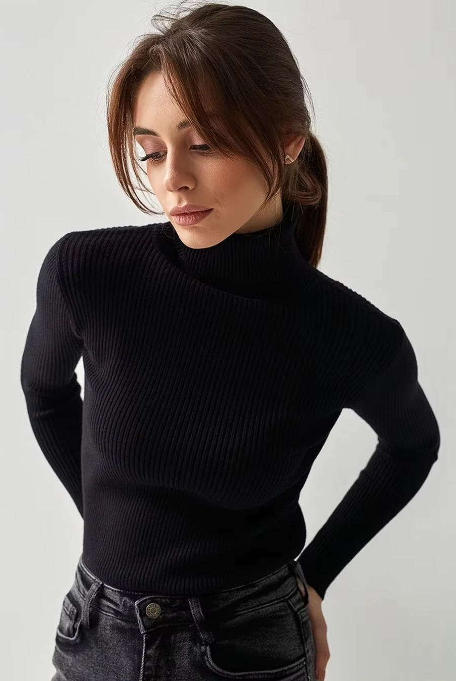 Woman wearing black ribbed turtleneck sweater, slim fit long sleeve