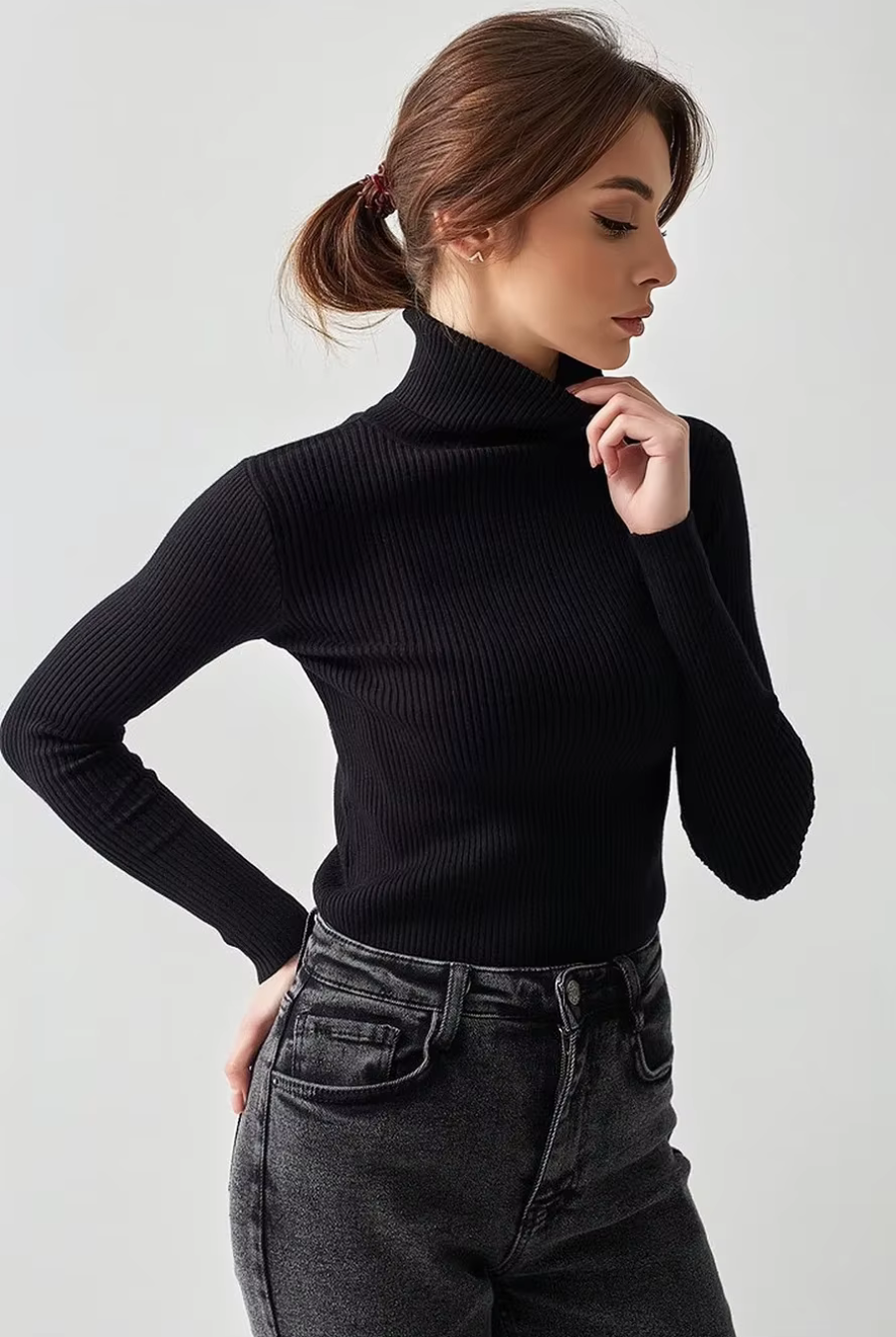Side view of fitted black turtleneck knit top with long sleeves