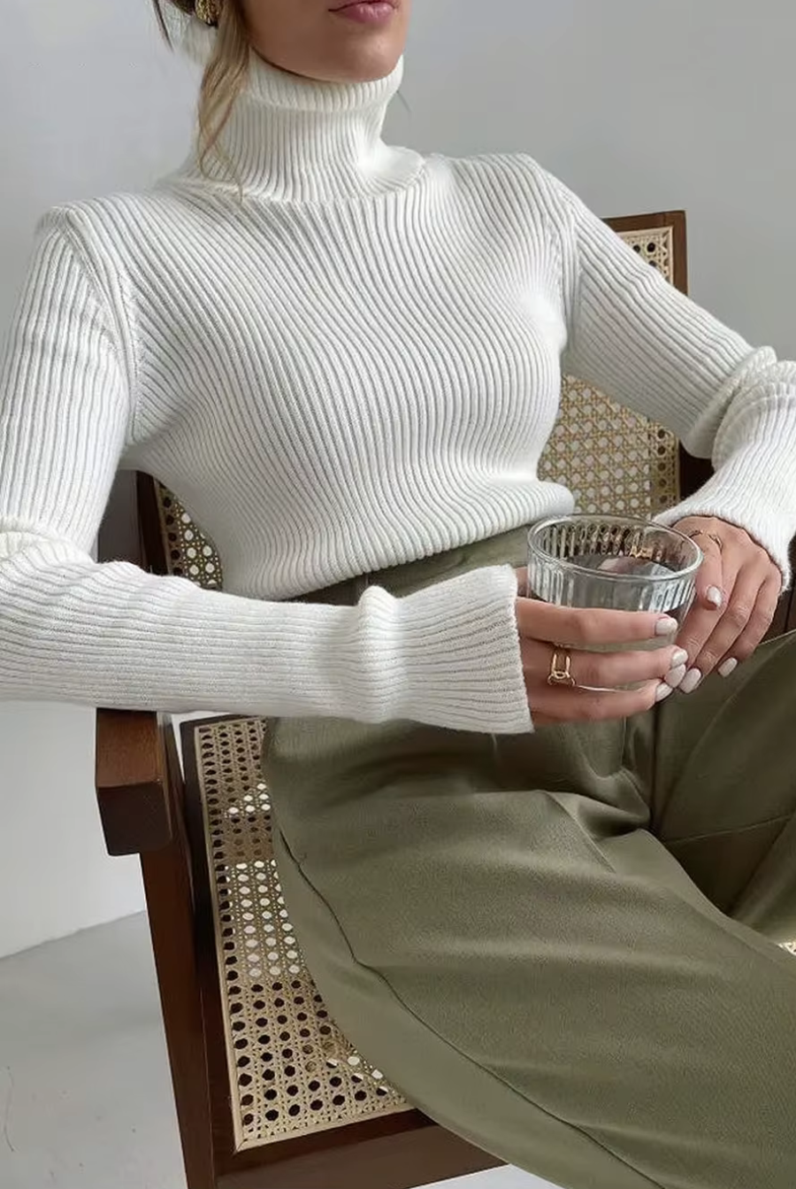 Woman wearing white ribbed turtleneck sweater, slim fit long sleeve