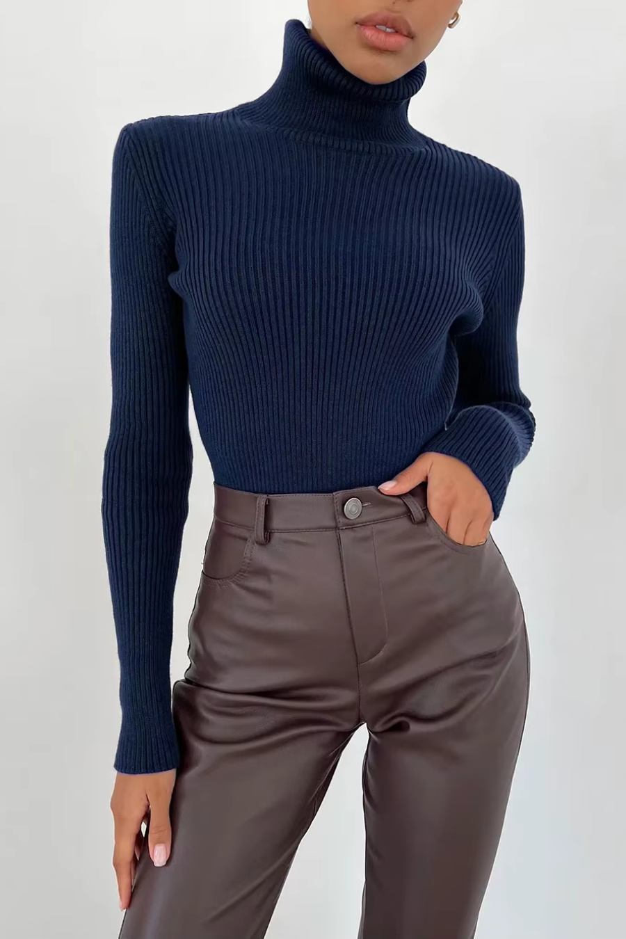 Woman wearing navy ribbed turtleneck sweater, slim fit long sleeve