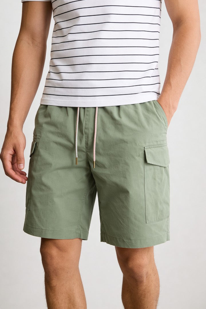 Men’s sage green utility cargo shorts with drawstring waist and side cargo pockets in lightweight fabric close-up