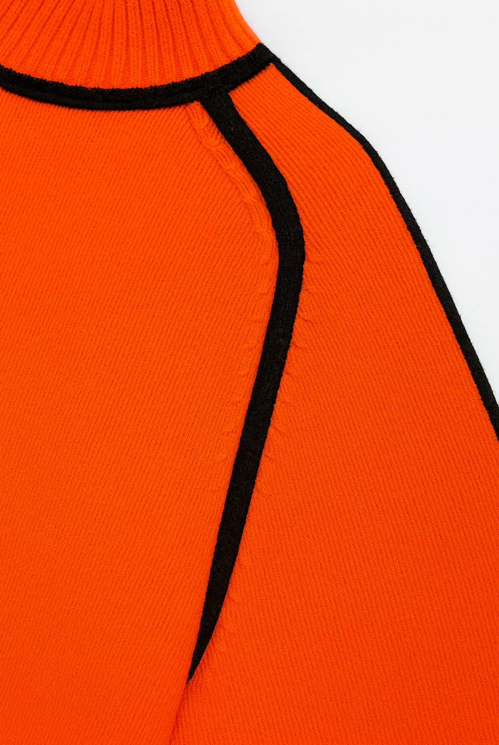 Close-up of an orange sweater with black trim on a white background