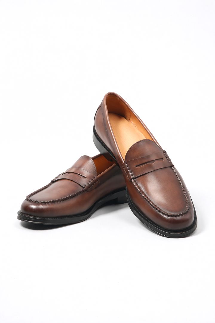 Premium men’s leather penny loafers with classic slip-on silhouette and refined stitching detail top view