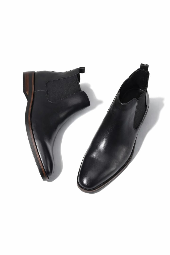 Premium men’s leather Chelsea boots in black with elastic side panels and sleek slip-on ankle boot design close-up
