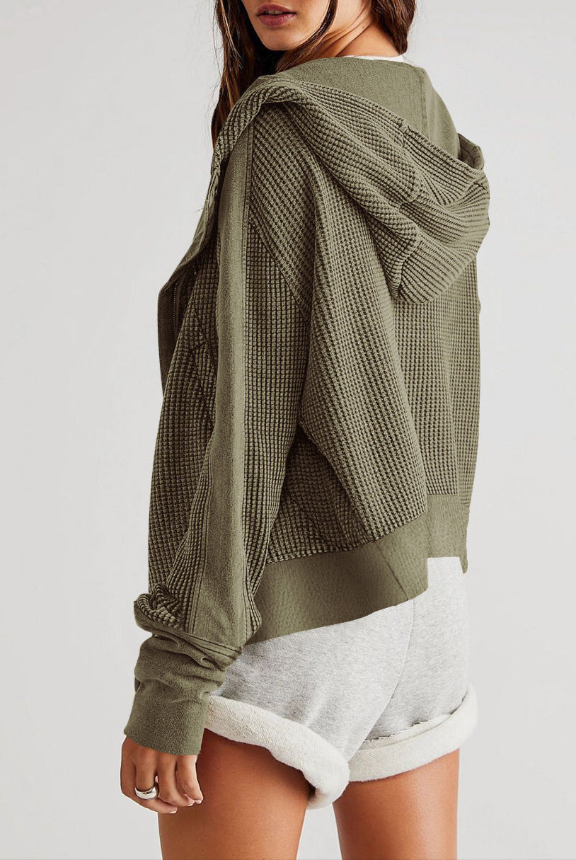 Person wearing a green textured hoodie on a white background