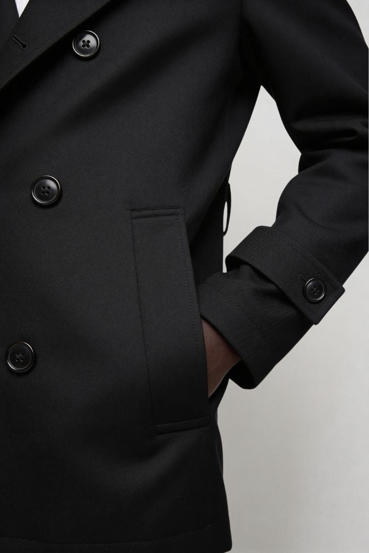 Men’s black double breasted trench coat close-up view
