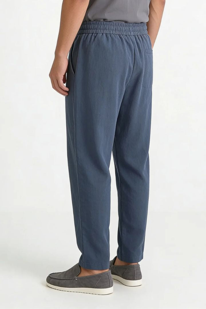 Men wearing steel blue linen drawstring trousers relaxed straight fit lightweight summer linen pants back view