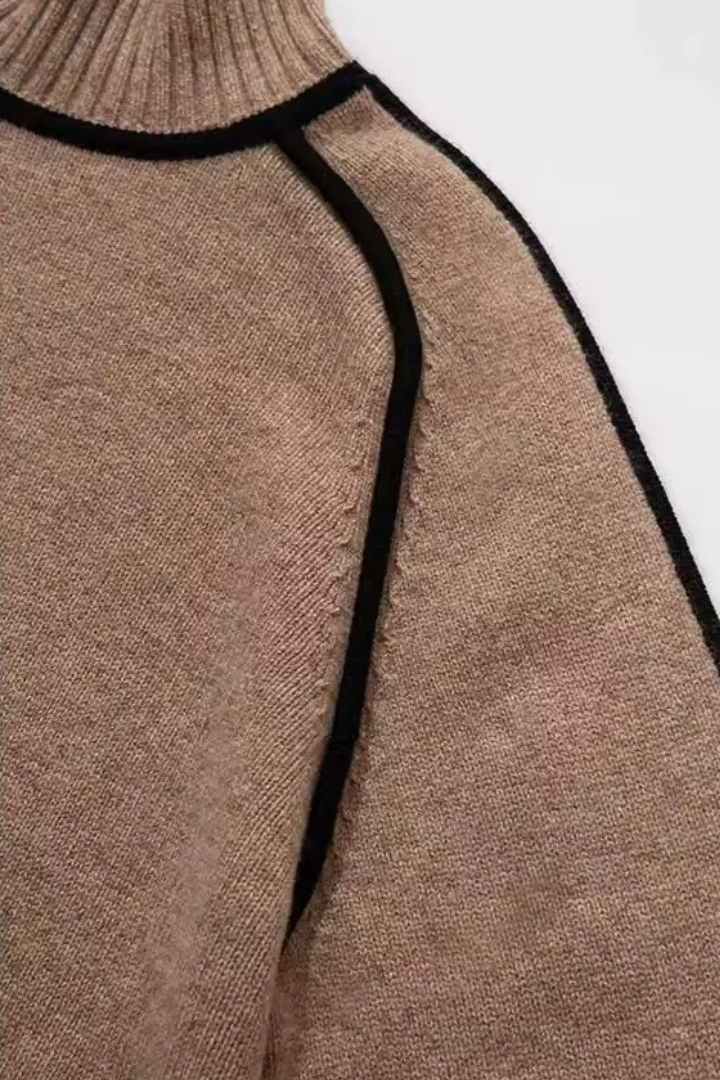 Close-up of a brown sweater with black trim on a white background