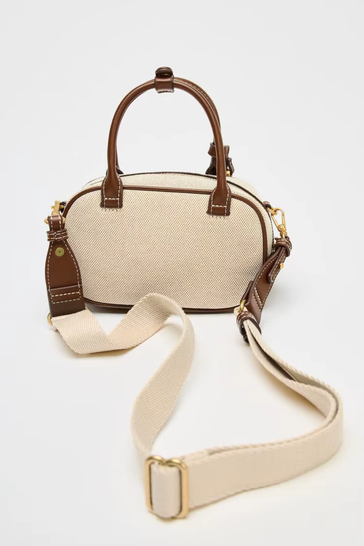 Beige handbag with brown accents on a white background
