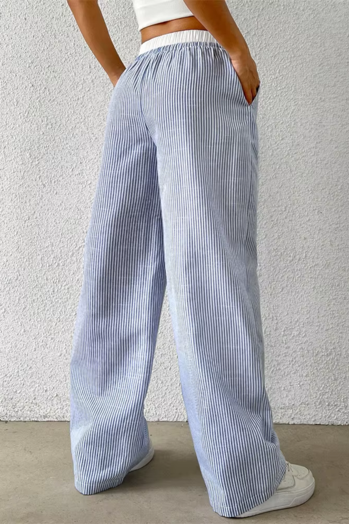 Person wearing blue and white striped pants against a plain background