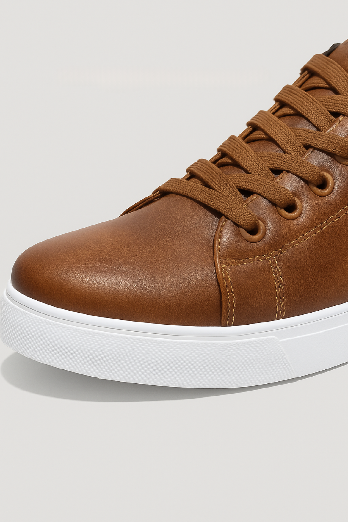 Brown leather sneaker with white sole on a light gray background