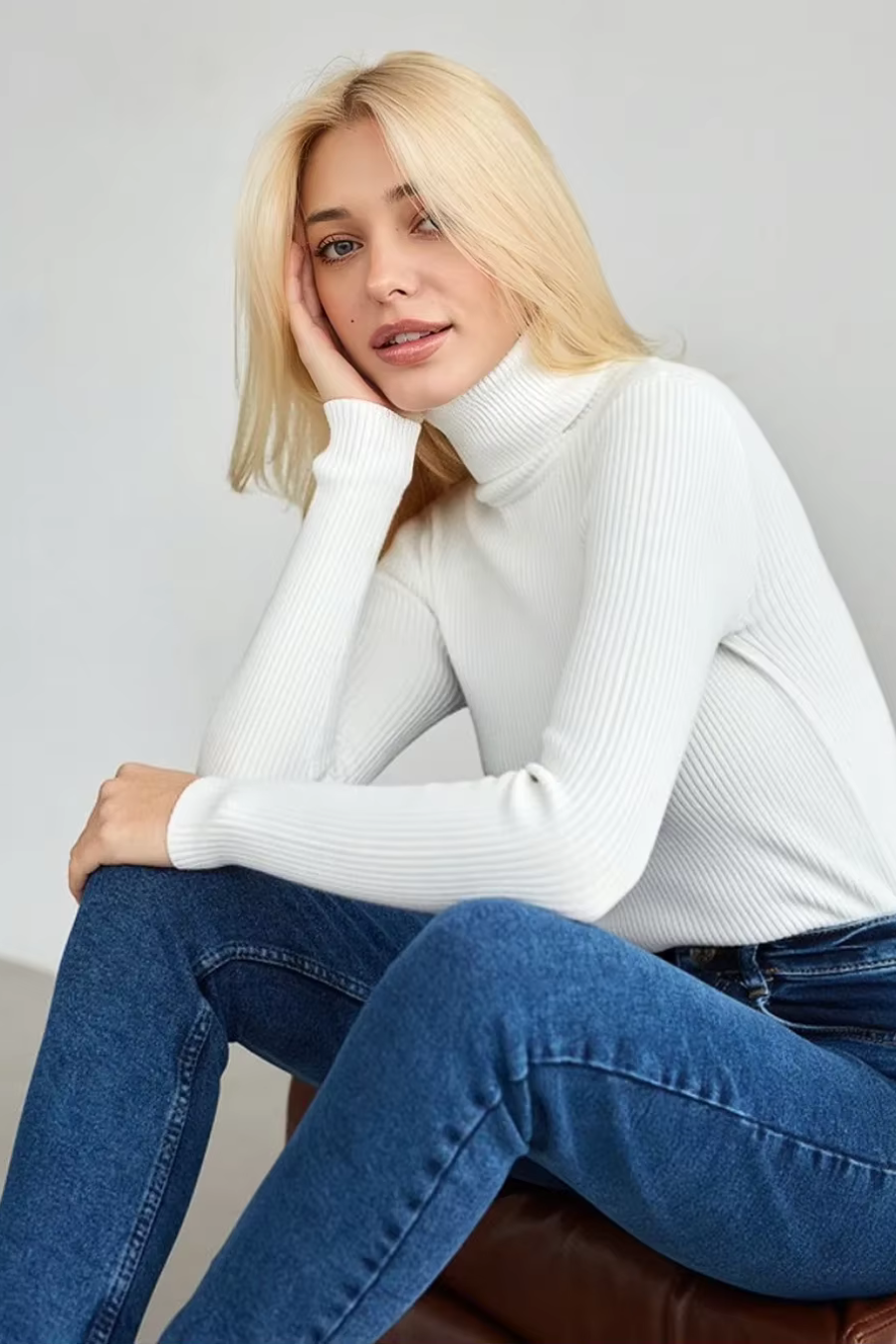 Front view of women’s white ribbed turtleneck styled with jeans