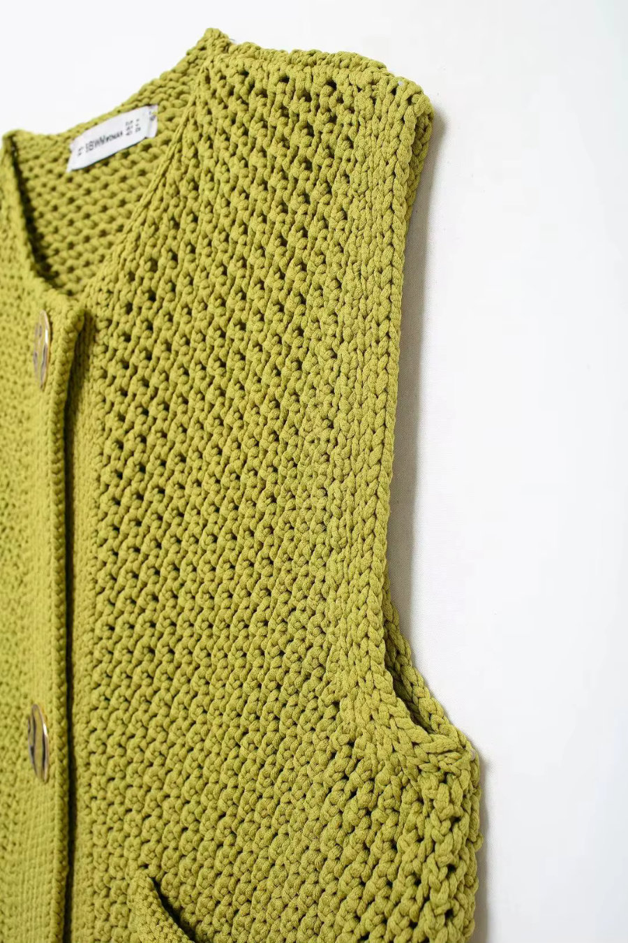 Details green knitted vest on a white background
