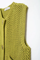 Details green knitted vest on a white background