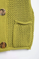 Green knitted cardigan with button details on a white background