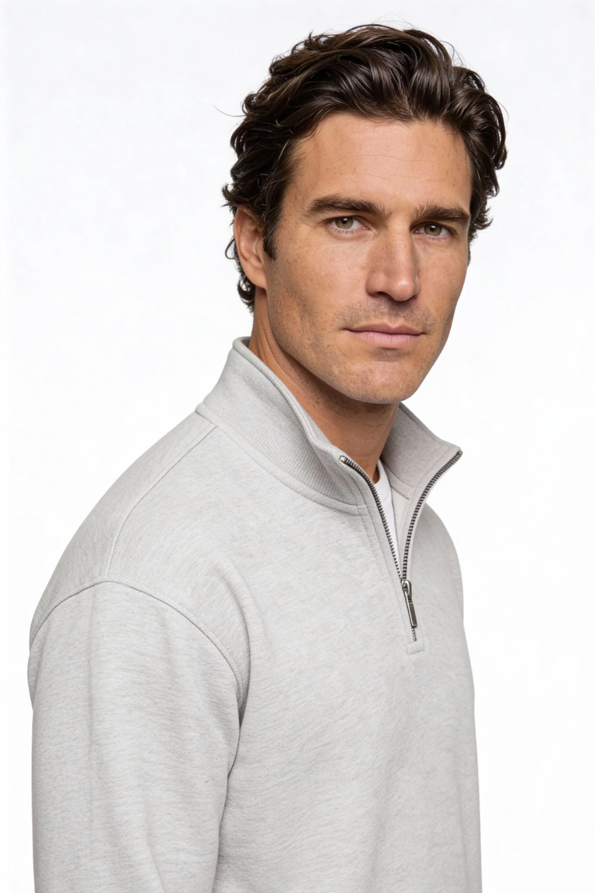 Man wearing a light gray zip-up sweater against a white background