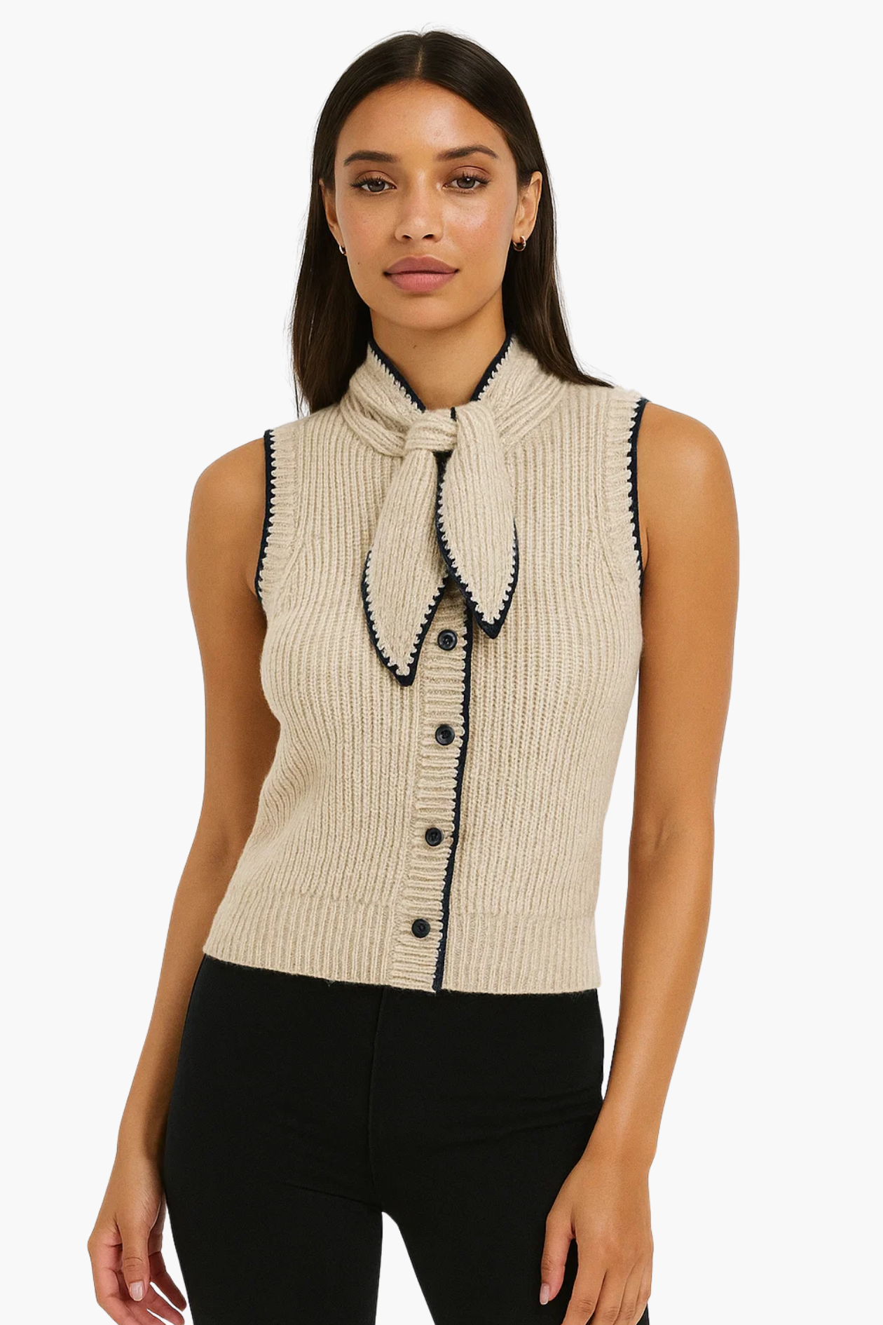 Woman wearing a beige sleeveless knitted top with black buttons and trim on a white background