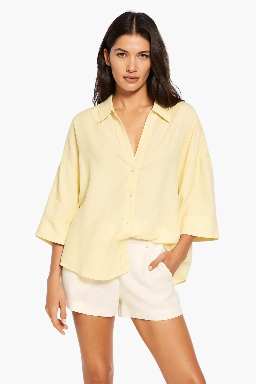 Woman wearing a light yellow shirt and white shorts on a white background