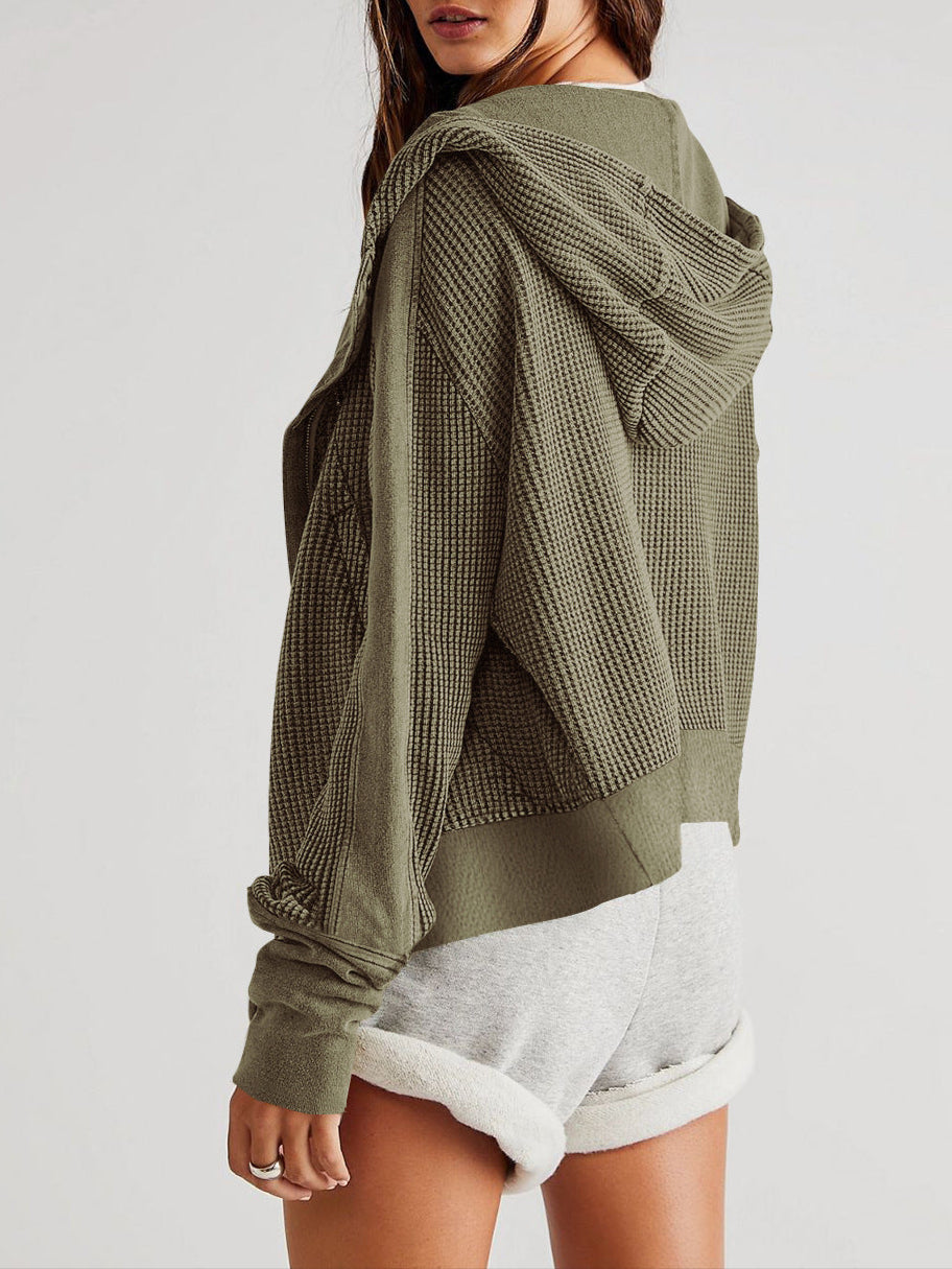 Person wearing a green textured hoodie on a white background