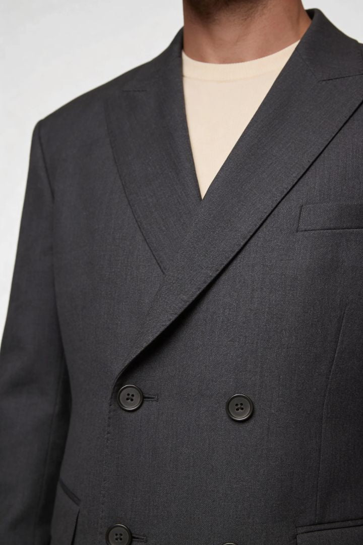 Gray double-breasted suit jacket with a beige shirt underneath on a white background