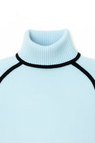 Light blue turtleneck sweater with black ribbed trim on a white background
